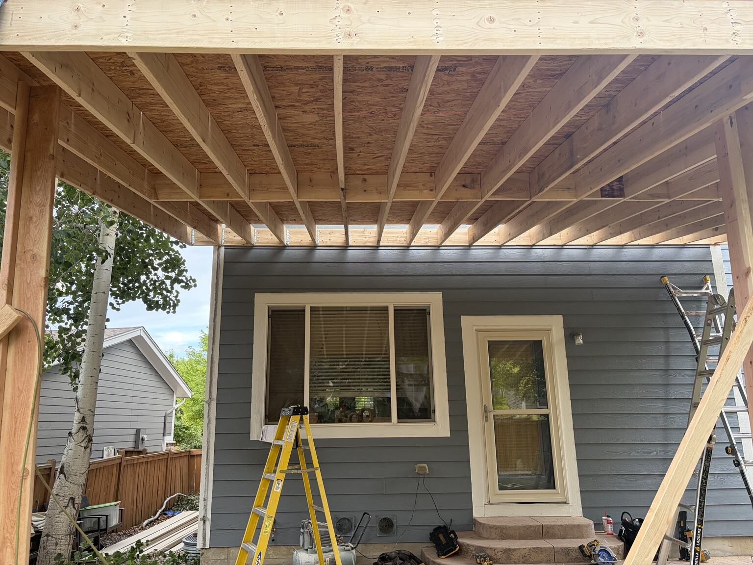 Underside view of patio-cover framing and structural connections